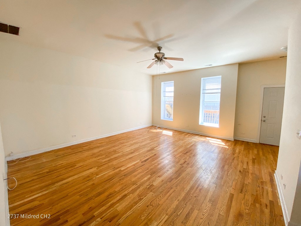 a bedroom with hardwood floors and a ceiling fan