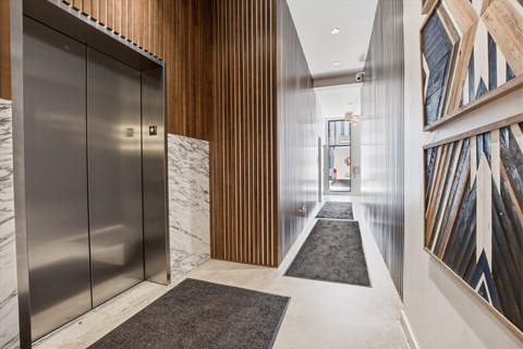 A hallway with a marble floor and a wooden wall.