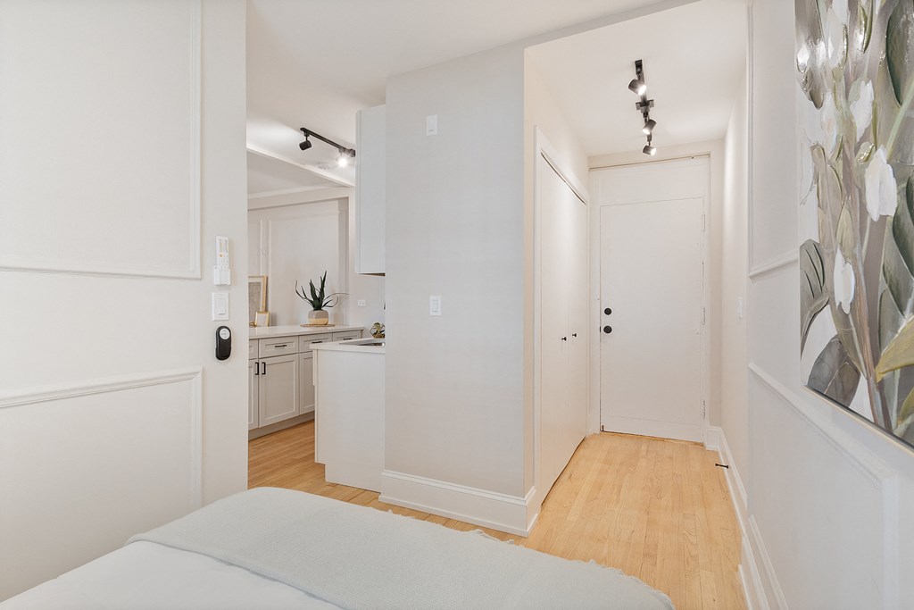 a bedroom with a bed and a door to a kitchen