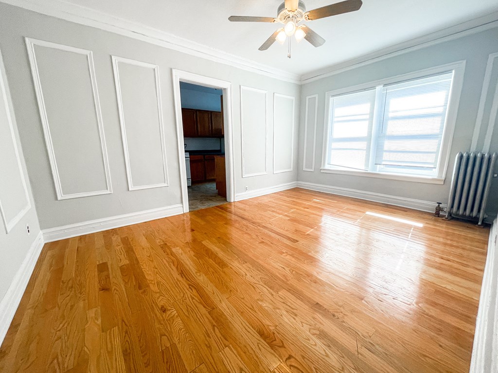 a living room with a hard wood floor and a ceiling fan