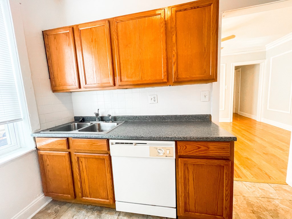 an empty kitchen with wooden cabinets and white appliances and a counter top