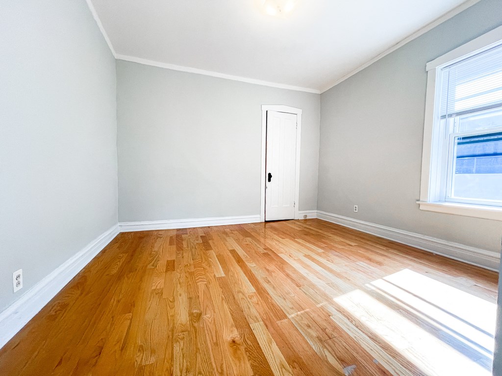 an empty room with wooden floors and a door
