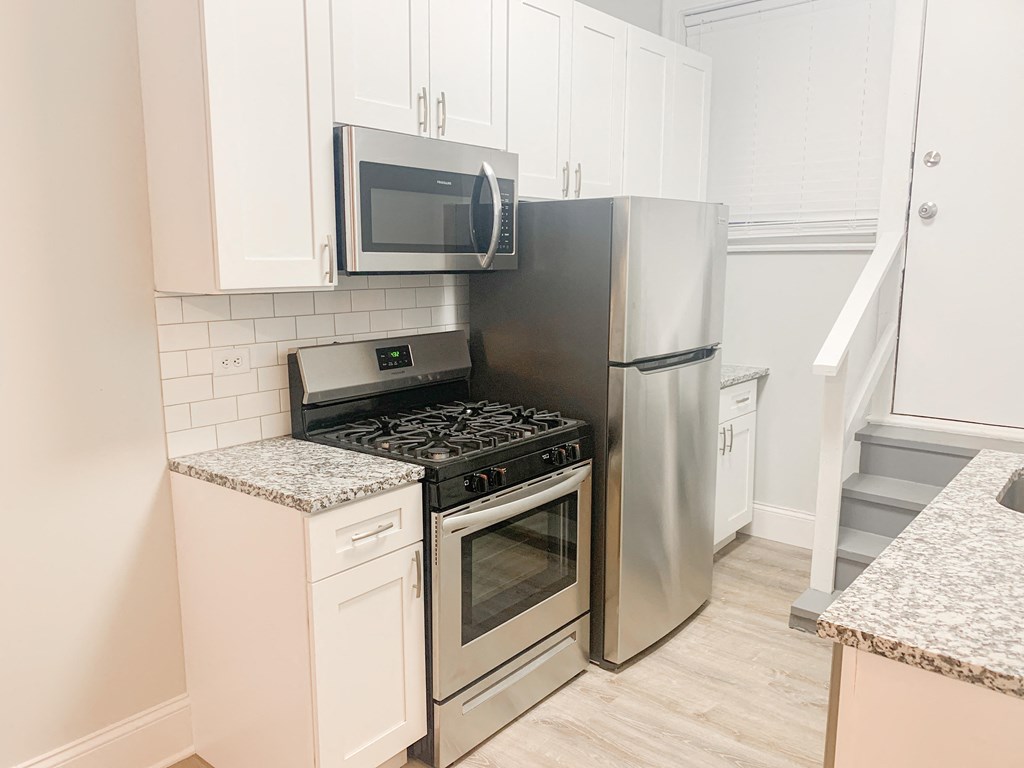 a kitchen with stainless steel appliances and white cabinets
