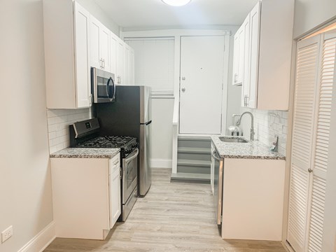 a kitchen with white cabinets and a stove and a refrigerator