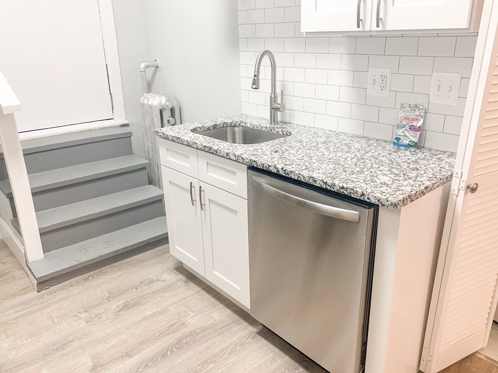 a small kitchen with a sink and a stainless steel dishwasher