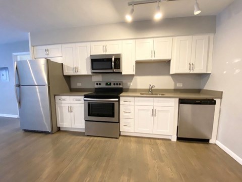 A kitchen with white cabinets and stainless steel appliances.
