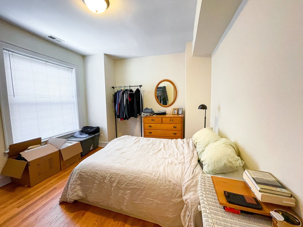 a bedroom with a bed and boxes on the floor