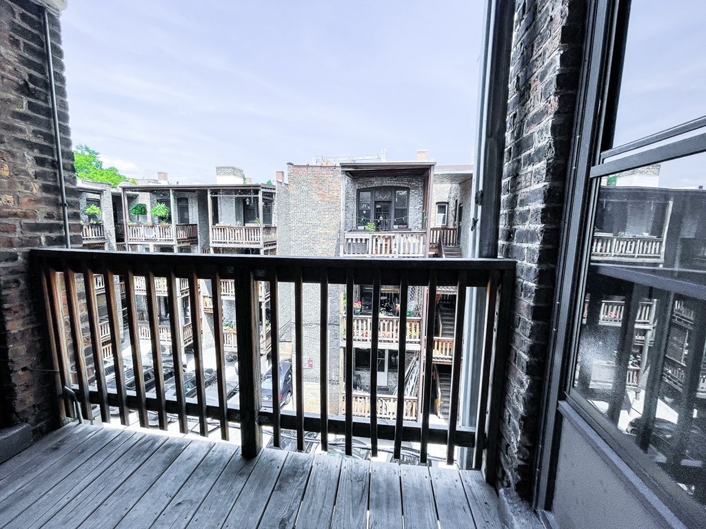 a balcony with a wooden deck and a brick building