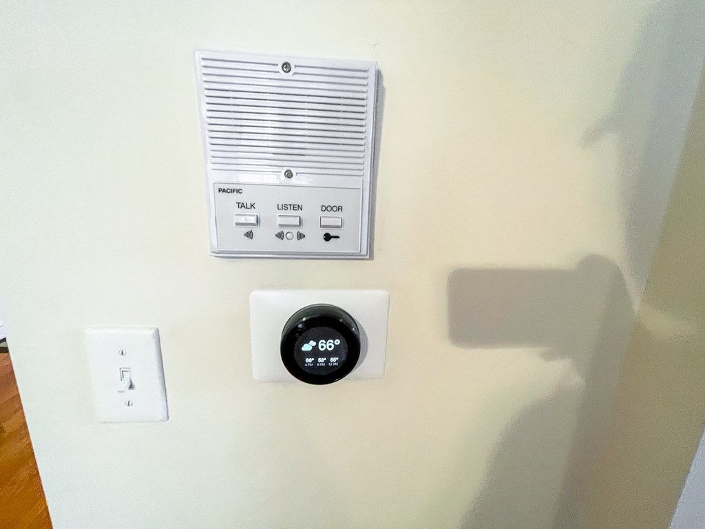 a wall thermostat and a control panel on a wall