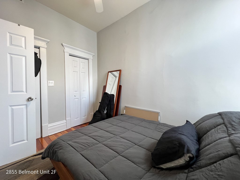 A bedroom with a bed, a mirror, and a door.