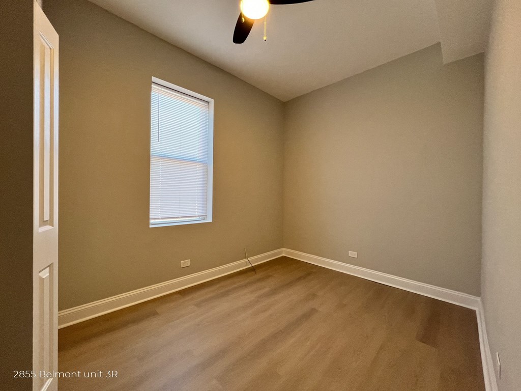 the bedroom of a house with wooden floors and a window