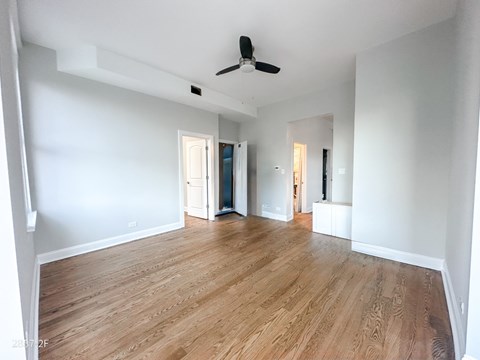 A room with wooden flooring and a ceiling fan.