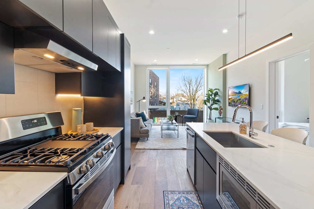 a kitchen with a sink and stove and a large window