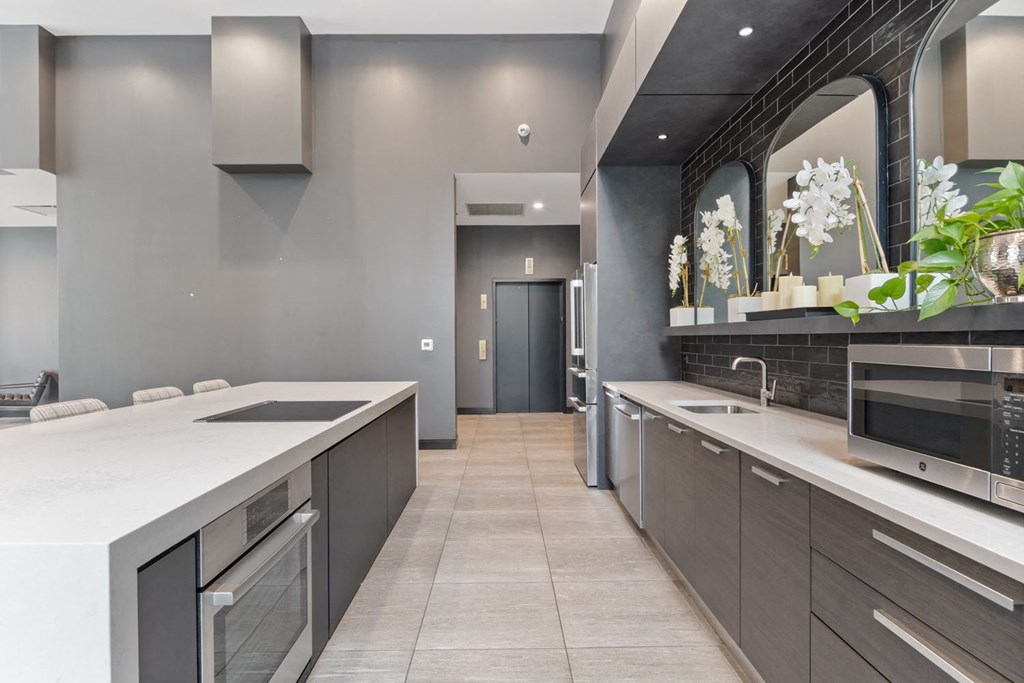 a kitchen with gray cabinets and white countertops