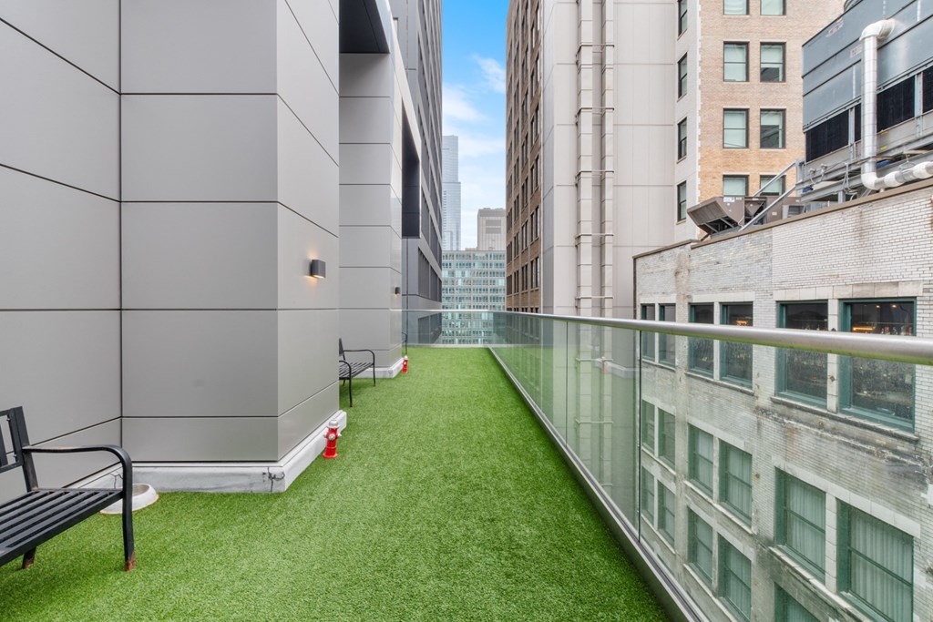 a balcony with a grassy area and a bench on it