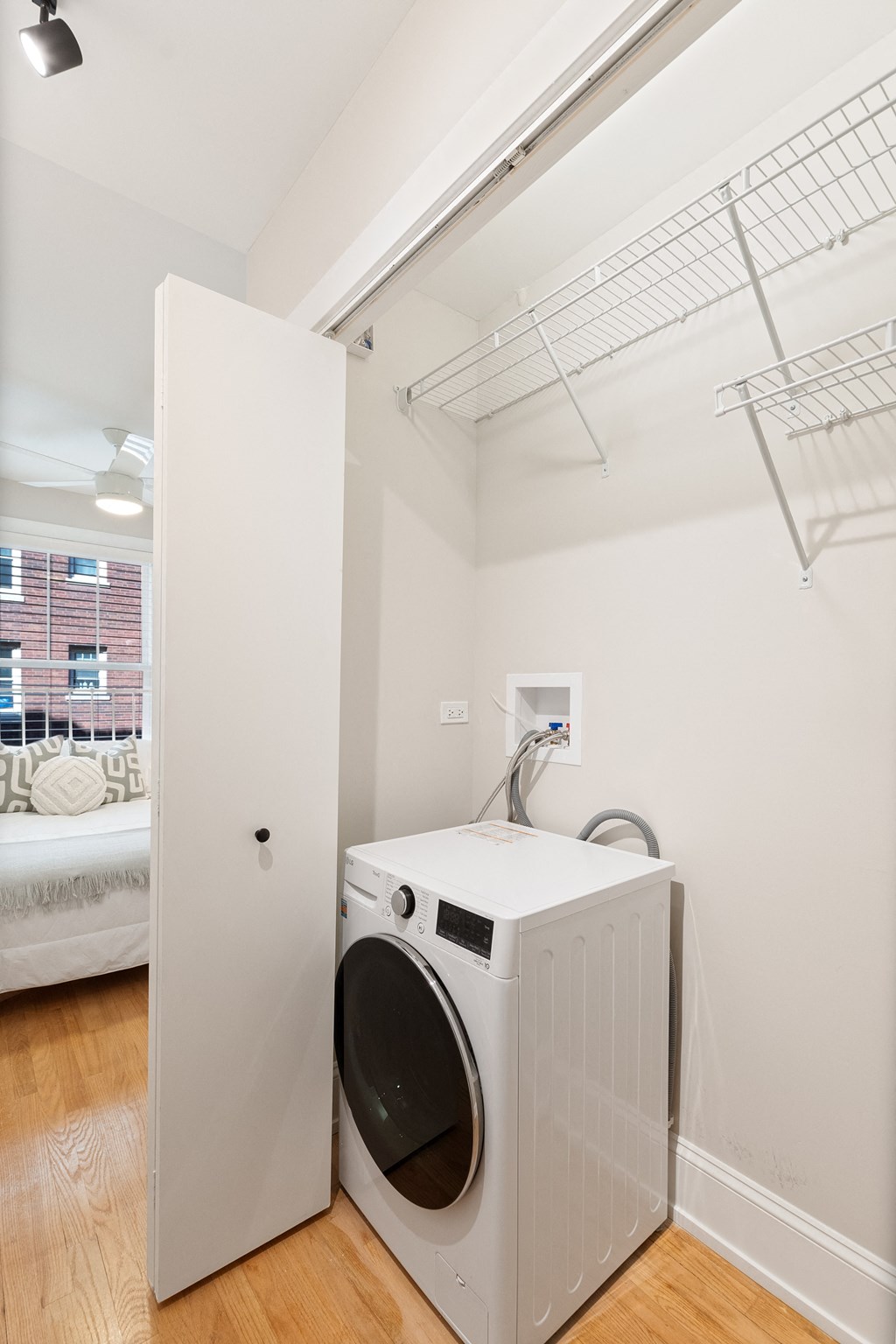 a front loading washer and dryer in a white room with a white door