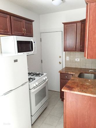 a kitchen with white appliances and brown cabinets