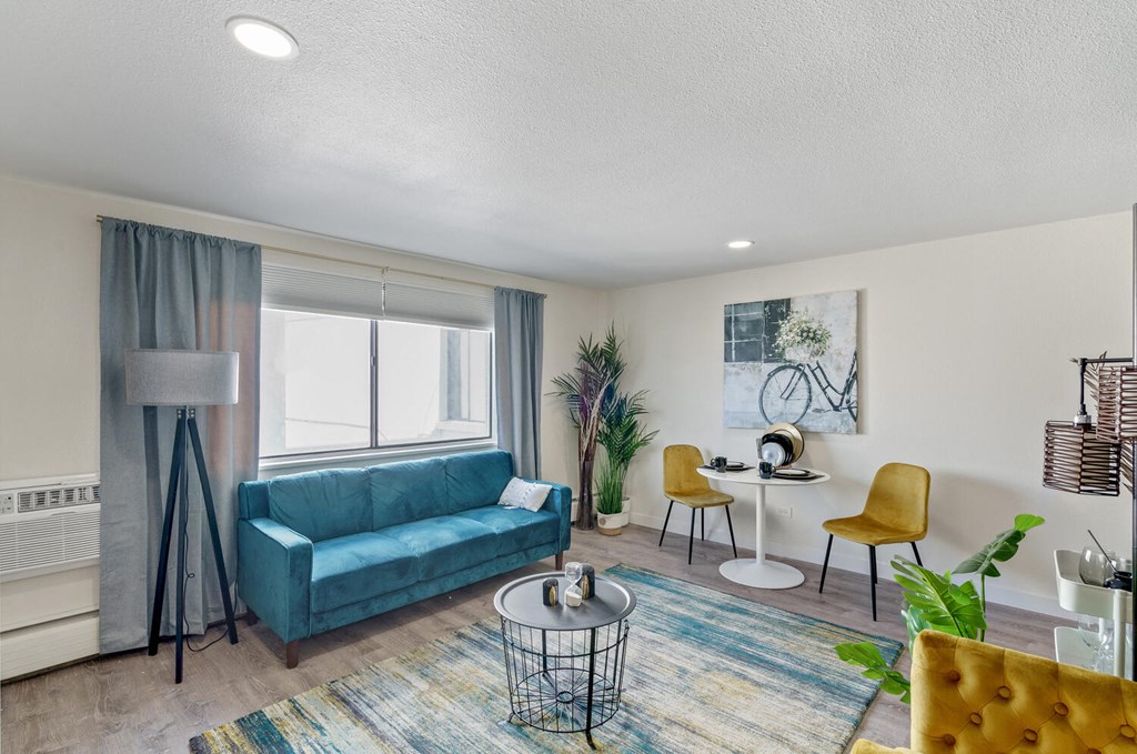 a living room with a blue couch and yellow chairs