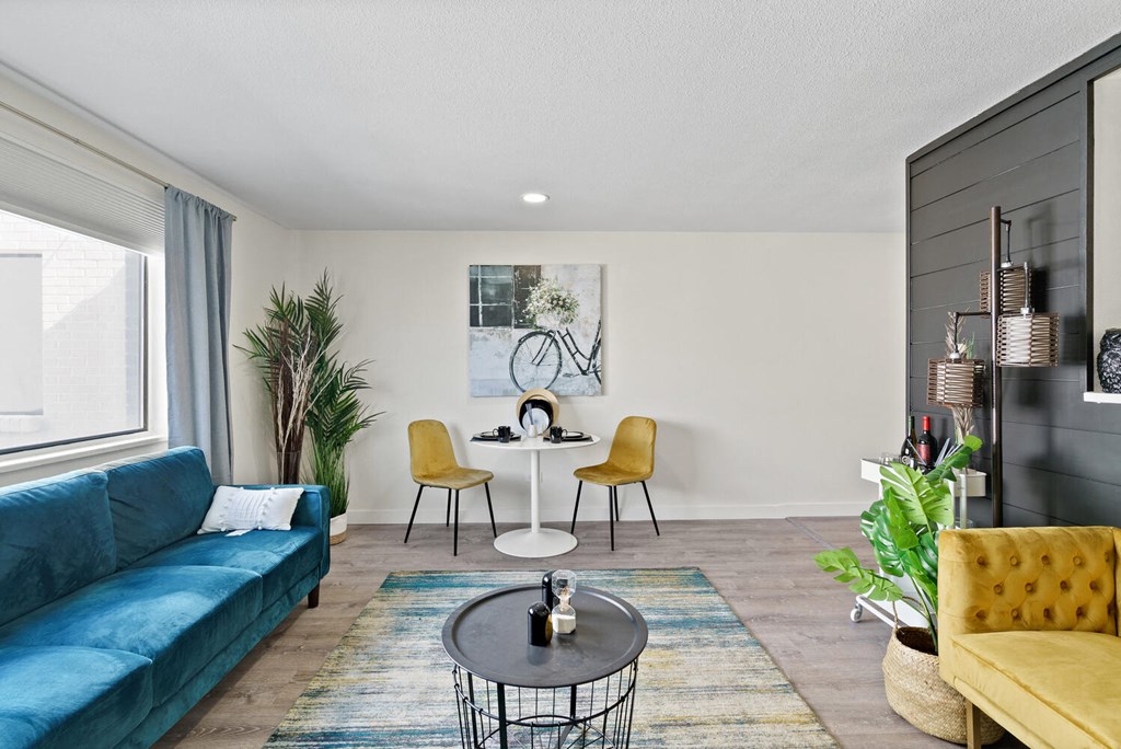 a living room with a blue couch and yellow chairs