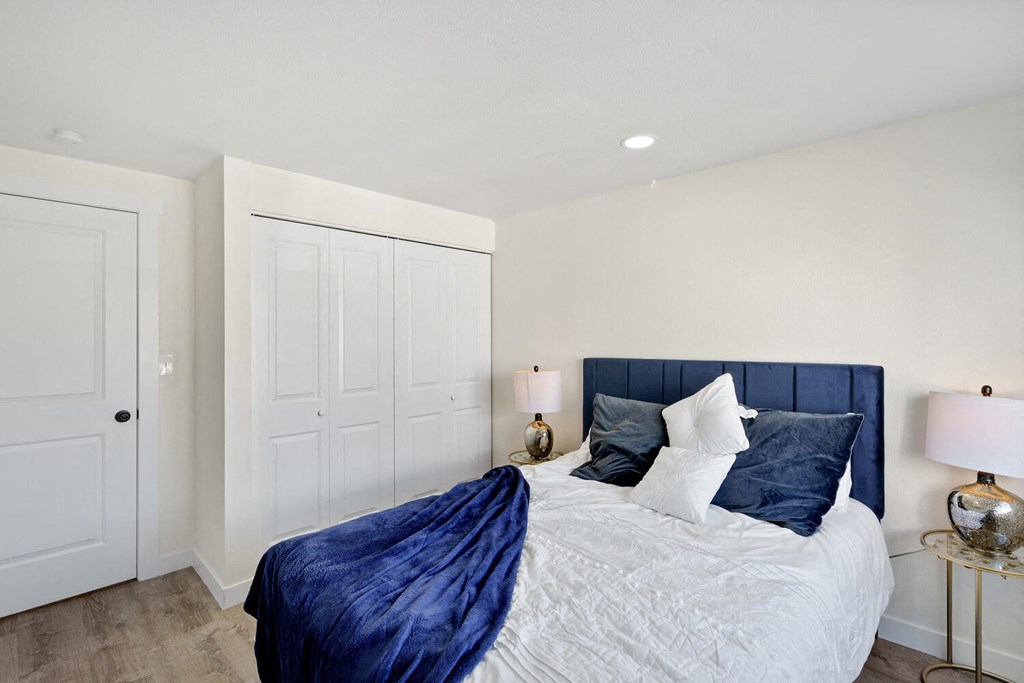 a bedroom with white walls and a blue headboard