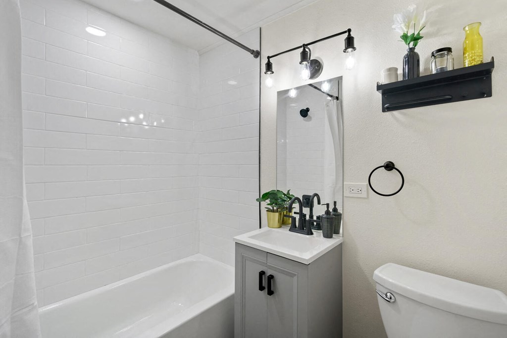 a bathroom with a white toilet next to a bathtub