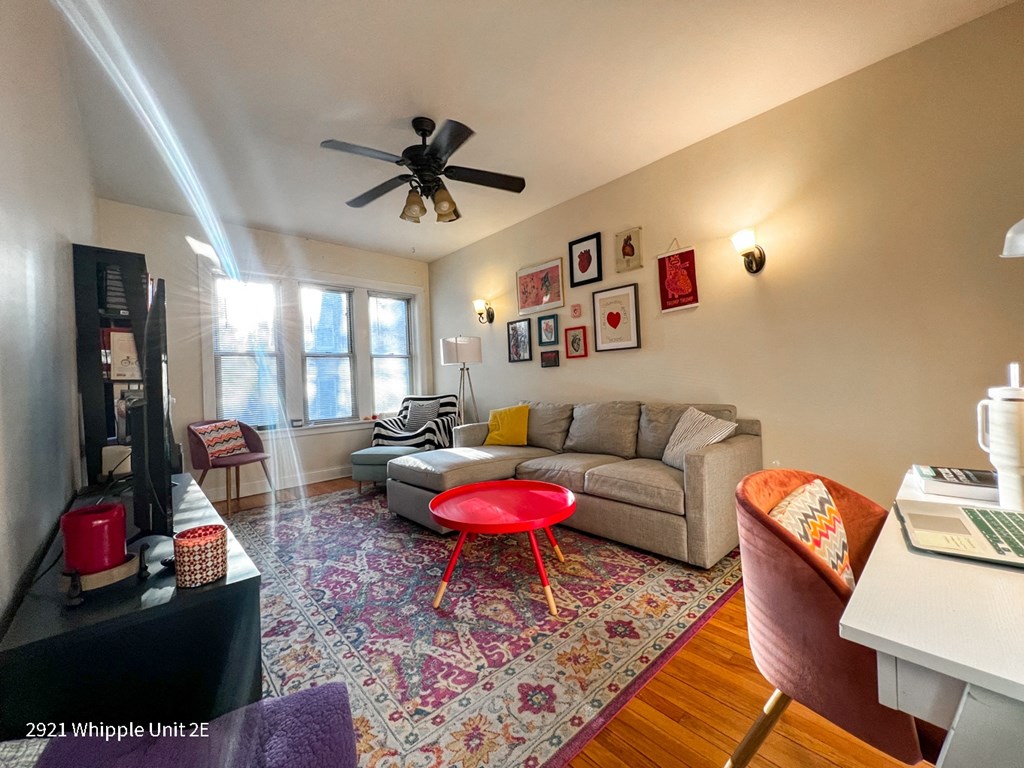 A living room with a couch, a chair, a table, and a rug.