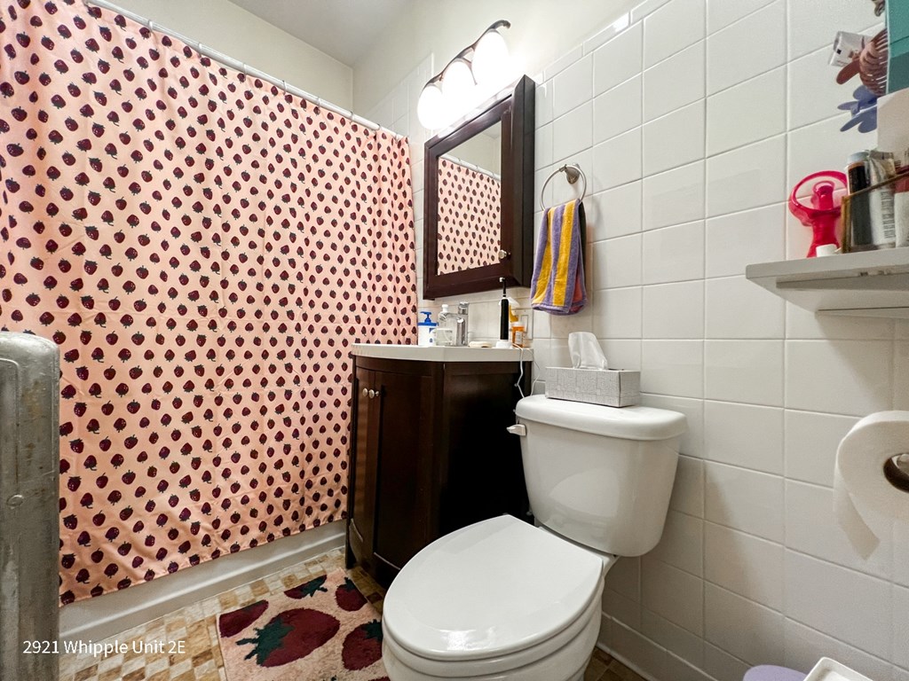 A bathroom with a toilet, sink, and shower curtain.