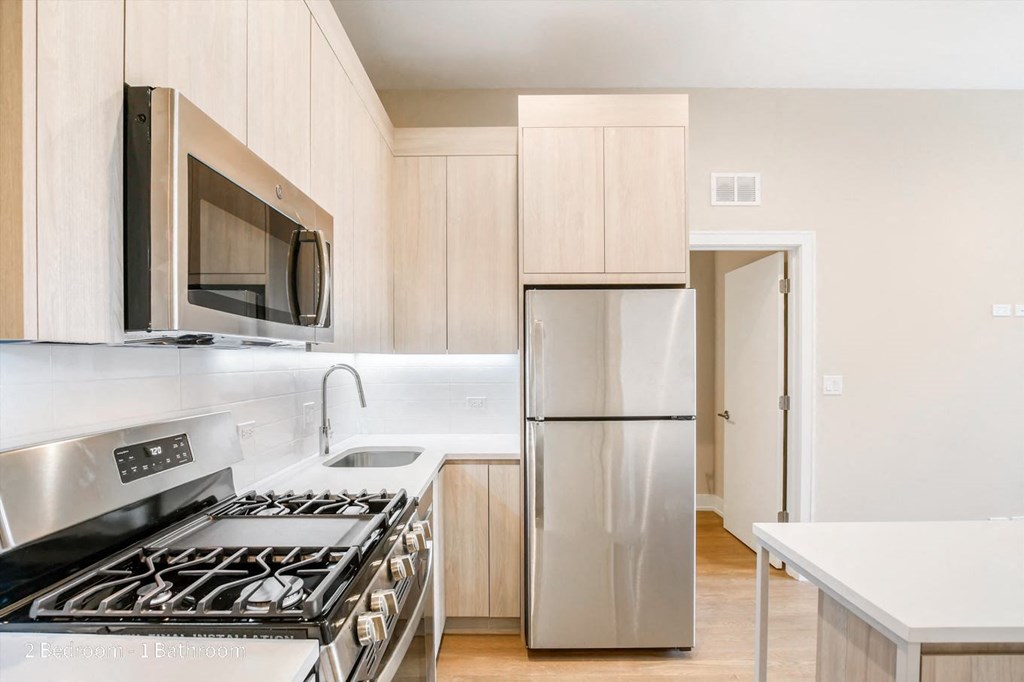 a kitchen with white cabinets and stainless steel appliances