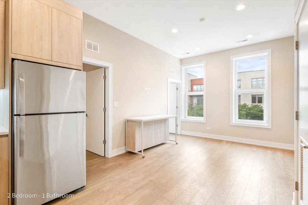 an empty kitchen and living room with two windows