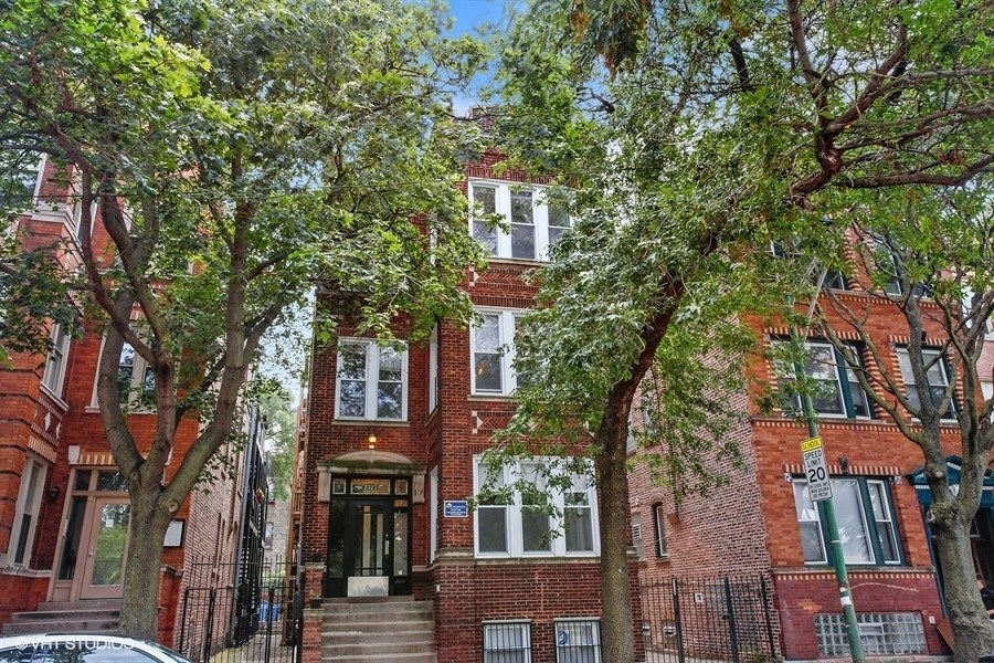 a red brick apartment building with trees in front of it