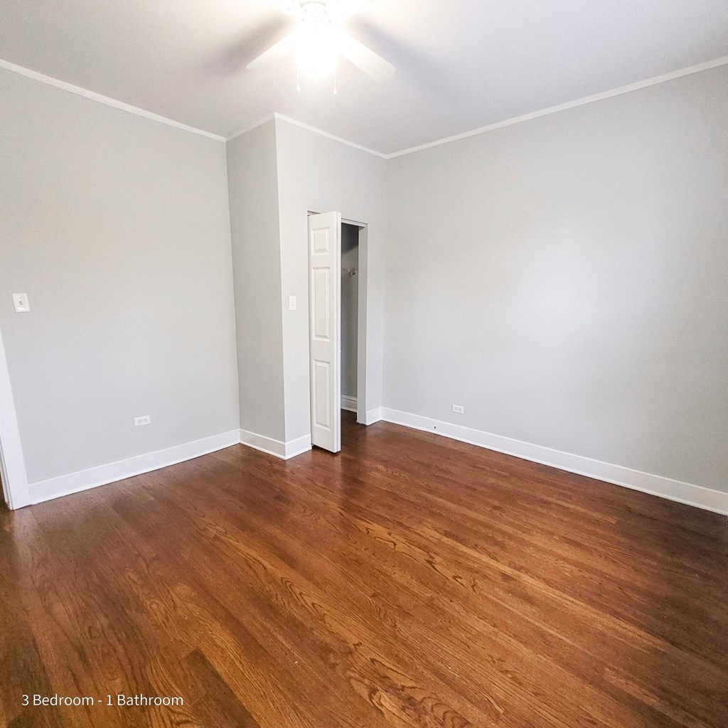 an empty living room with wood flooring and white walls