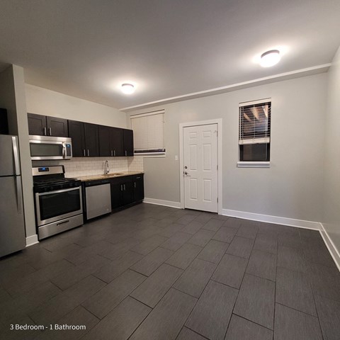 a kitchen with stainless steel appliances and black cabinets