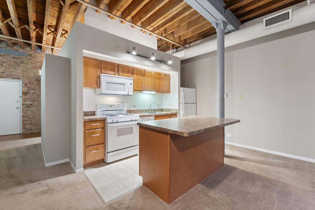a kitchen with an island and a stove and a refrigerator