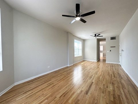 A room with wooden floors and a ceiling fan.