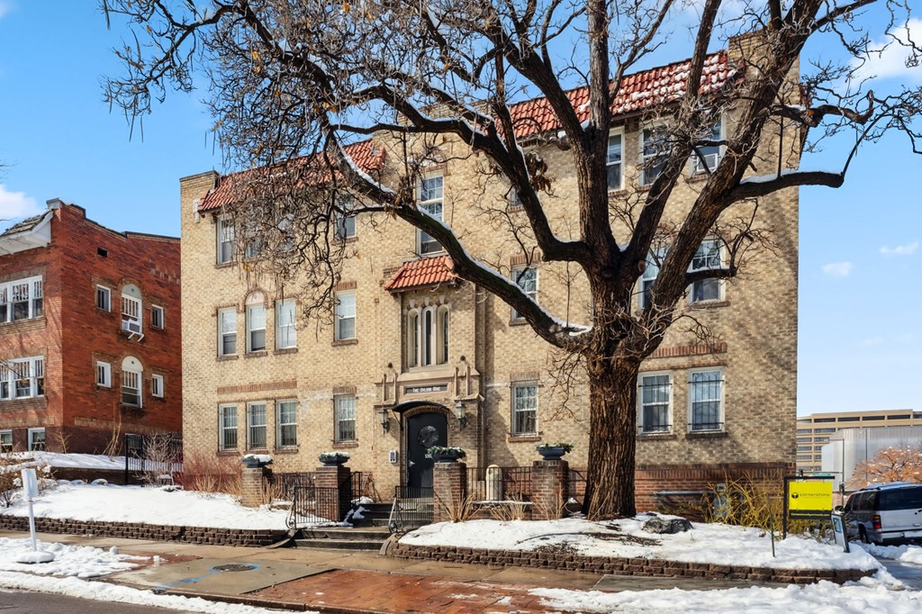 a large brick building with a tree in front of it