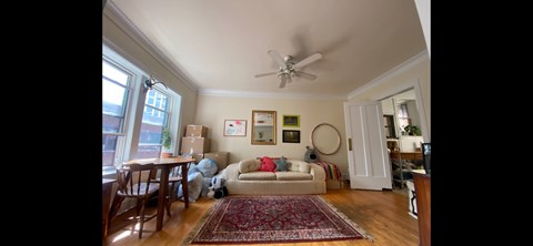 A living room with a couch, chairs, and a rug.