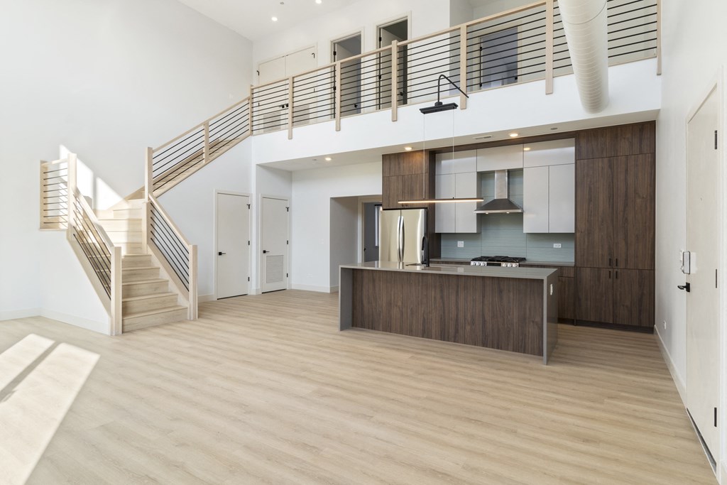 a living room with a kitchen and a staircase