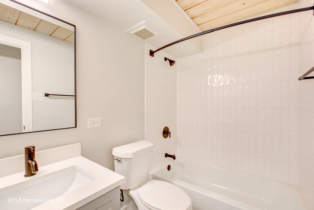 a bathroom with a white sink and toilet next to a white bathtub