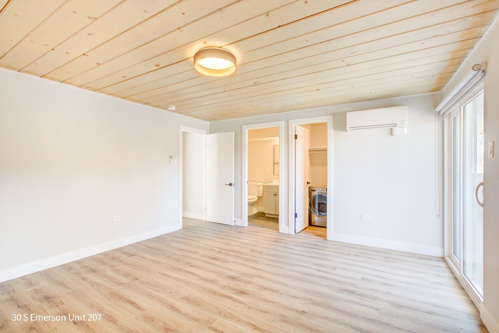 a living room with white walls and a wood ceiling