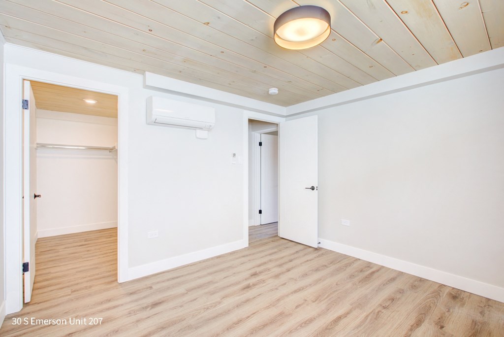 an empty room with white walls and wood floors