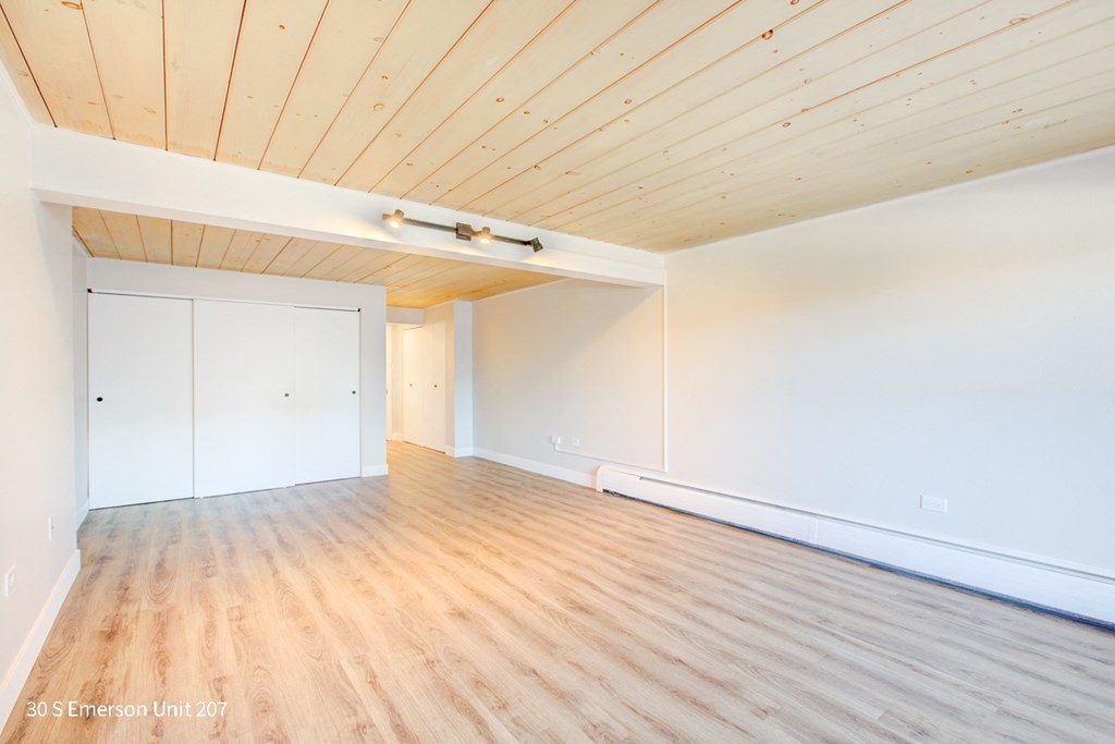 an empty room with white walls and wood floors