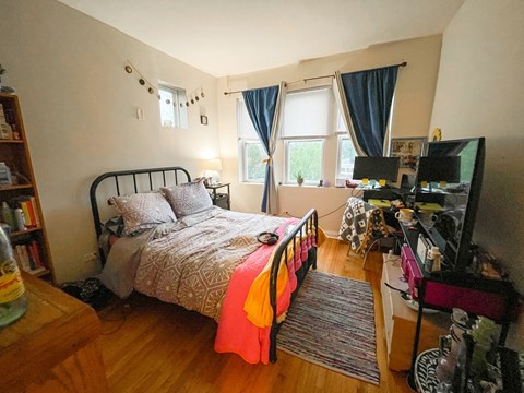 A bedroom with a bed, desk, and chair.