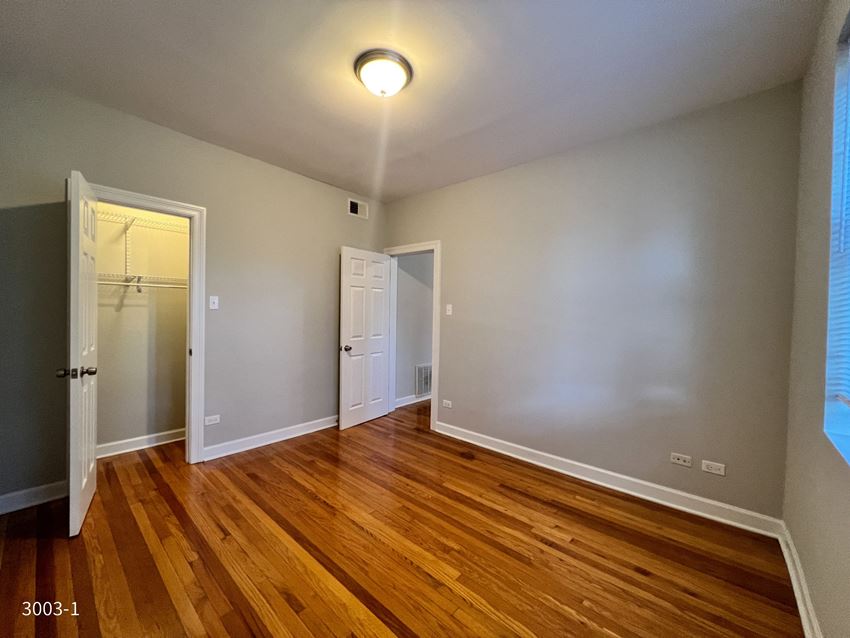 a bedroom with hardwood floors and grey walls - Photo Gallery