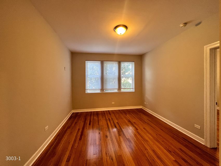 an empty room with hardwood floors and a window - Photo Gallery