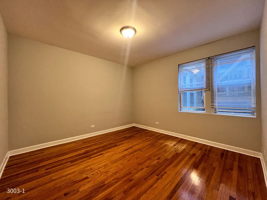 a bedroom with hardwood floors and a window - Photo Gallery