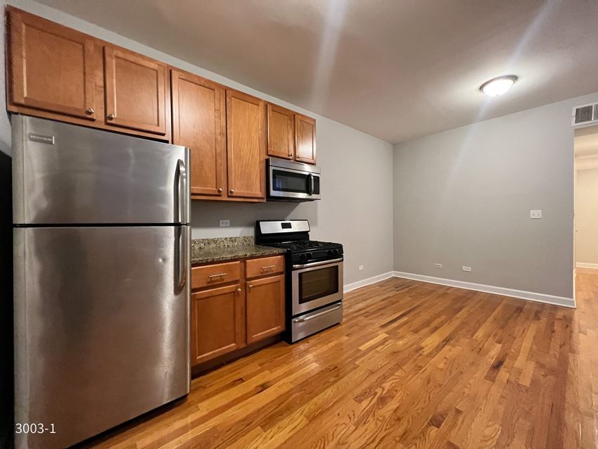 a kitchen with wood floors and stainless steel appliances - Photo Gallery