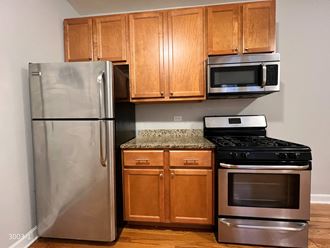 a kitchen with wooden cabinets and stainless steel appliances