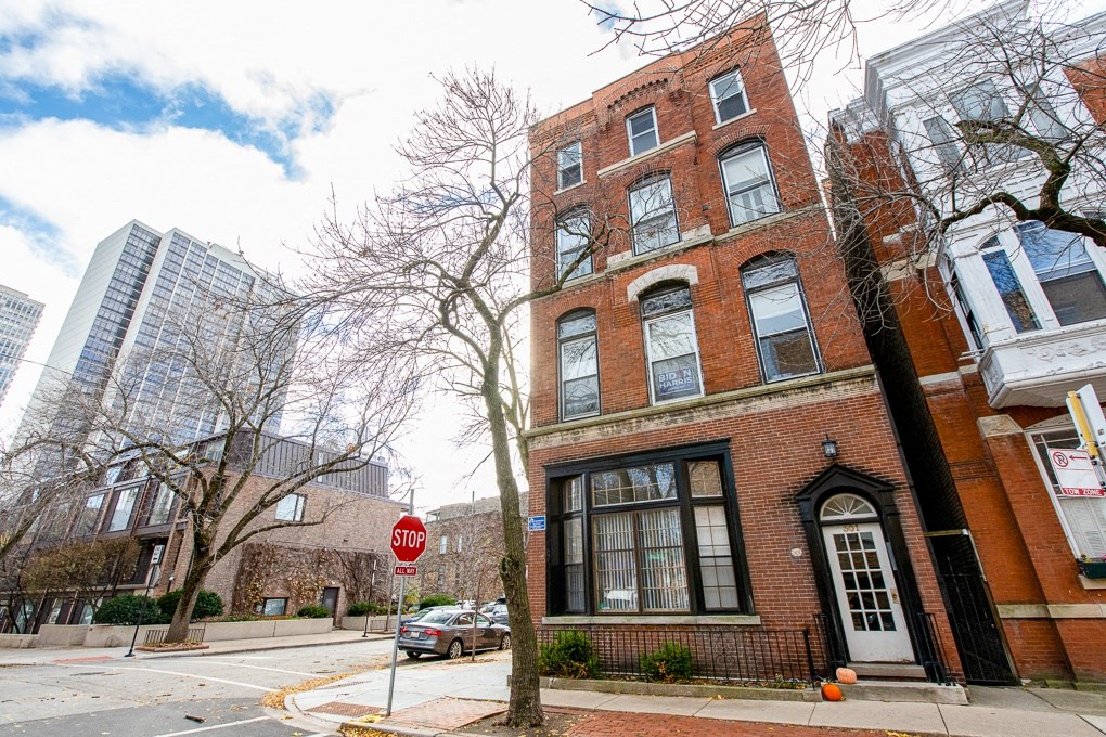 an old brick building with a stop sign in front of it