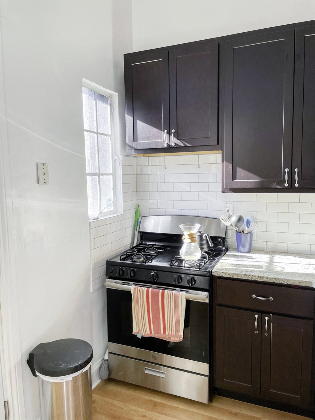 a small kitchen with a stove and black cabinets