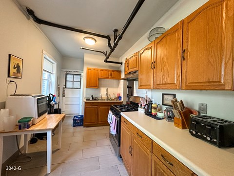 A kitchen with wooden cabinets and a black stove top oven.